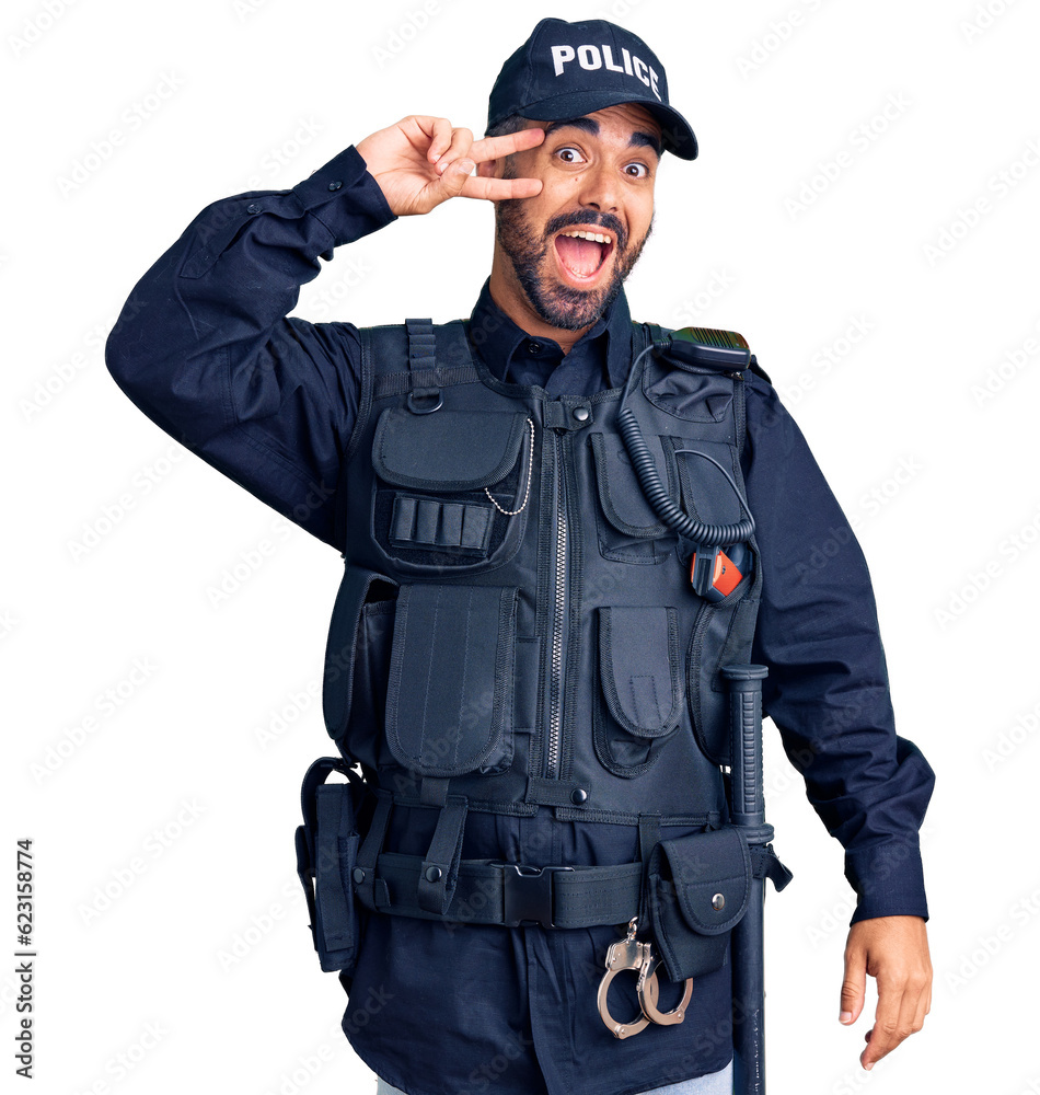 Young hispanic man wearing police uniform doing peace symbol with fingers over face, smiling cheerful showing victory Young hispanic man wearing police uniform doing peace symbol with fingers over face, smiling cheerful showing victory