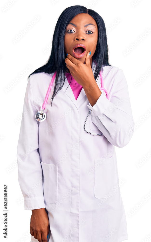 Young african american woman wearing doctor stethoscope looking fascinated with disbelief, surprise and amazed expression with hands on chin Young african american woman wearing doctor stethoscope looking fascinated with disbelief, surprise and amazed expression with hands on chin