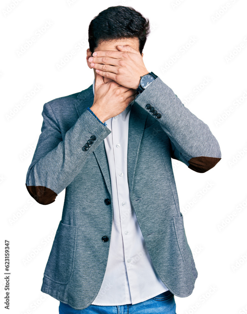 Young hispanic man wearing business clothes covering eyes and mouth with hands, surprised and shocked. hiding emotion Young hispanic man wearing business clothes covering eyes and mouth with hands, surprised and shocked. hiding emotion