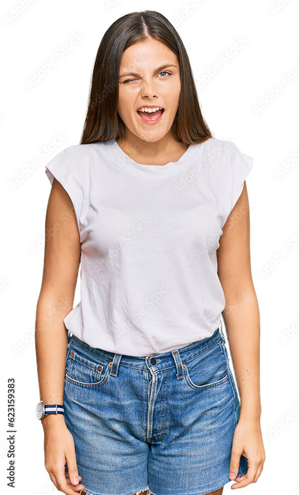 Young caucasian woman wearing casual white tshirt winking looking at the camera with sexy expression, cheerful and happy face. Young caucasian woman wearing casual white tshirt winking looking at the camera with sexy expression, cheerful and happy face.