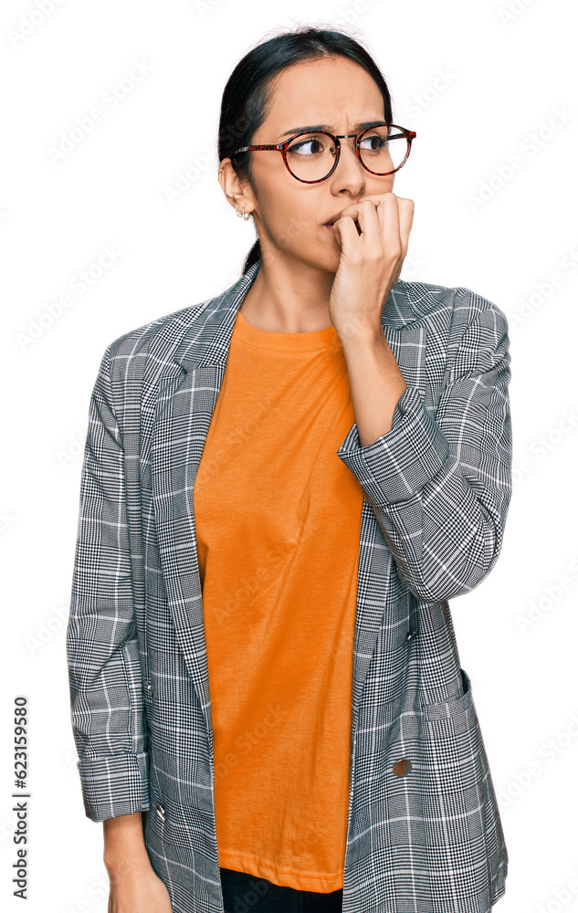 Young hispanic girl wearing business jacket and glasses looking stressed and nervous with hands on mouth biting nails. anxiety problem. Young hispanic girl wearing business jacket and glasses looking stressed and nervous with hands on mouth biting nails. anxiety problem.