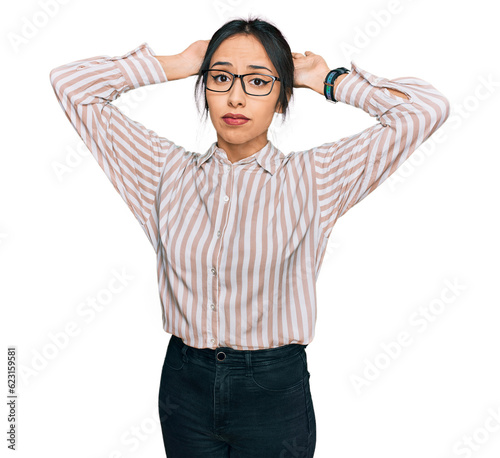 Young hispanic girl wearing casual clothes and glasses doing bunny ears gesture with hands palms looking cynical and skeptical. easter rabbit concept.