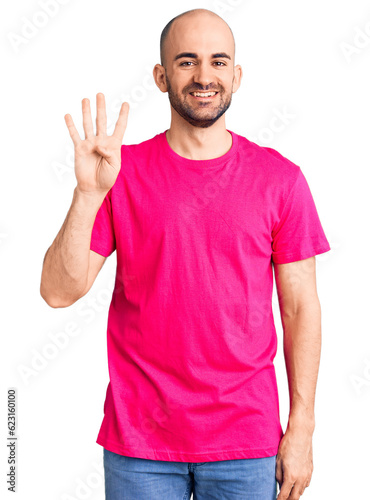 Young handsome man wearing casual t shirt showing and pointing up with fingers number four while smiling confident and happy.