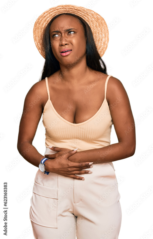 Young black woman wearing summer hat with hand on stomach because nausea, painful disease feeling unwell. ache concept. Young black woman wearing summer hat with hand on stomach because nausea, painful disease feeling unwell. ache concept.