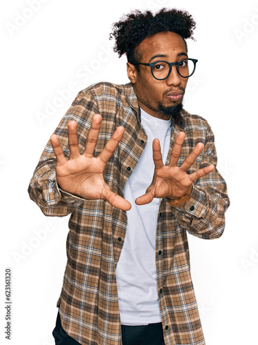 Photography Young african american man with beard wearing casual clothes and glasses moving away hands palms showing refusal and denial with afraid and disgusting expression