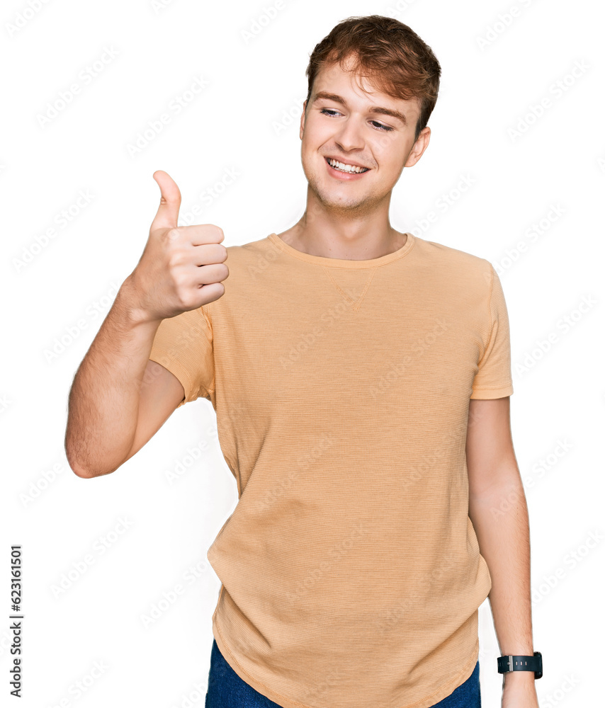 Young caucasian man wearing casual clothes looking proud, smiling doing thumbs up gesture to the side Young caucasian man wearing casual clothes looking proud, smiling doing thumbs up gesture to the side