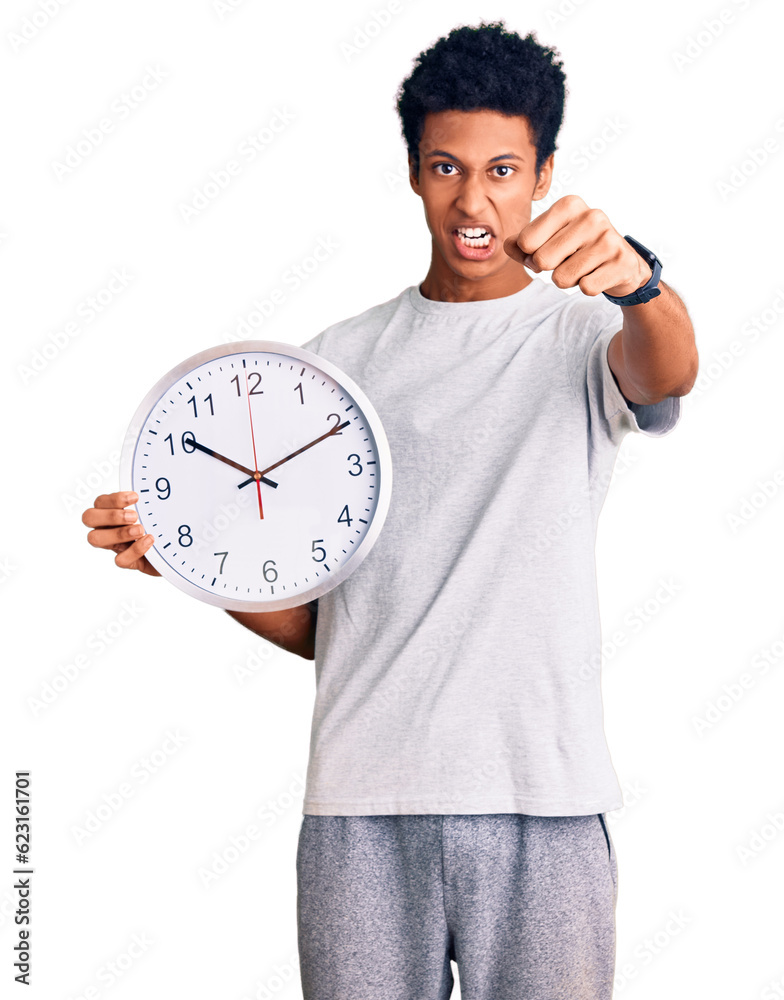 Young african american man holding big clock annoyed and frustrated shouting with anger, yelling crazy with anger and hand raised Young african american man holding big clock annoyed and frustrated shouting with anger, yelling crazy with anger and hand raised