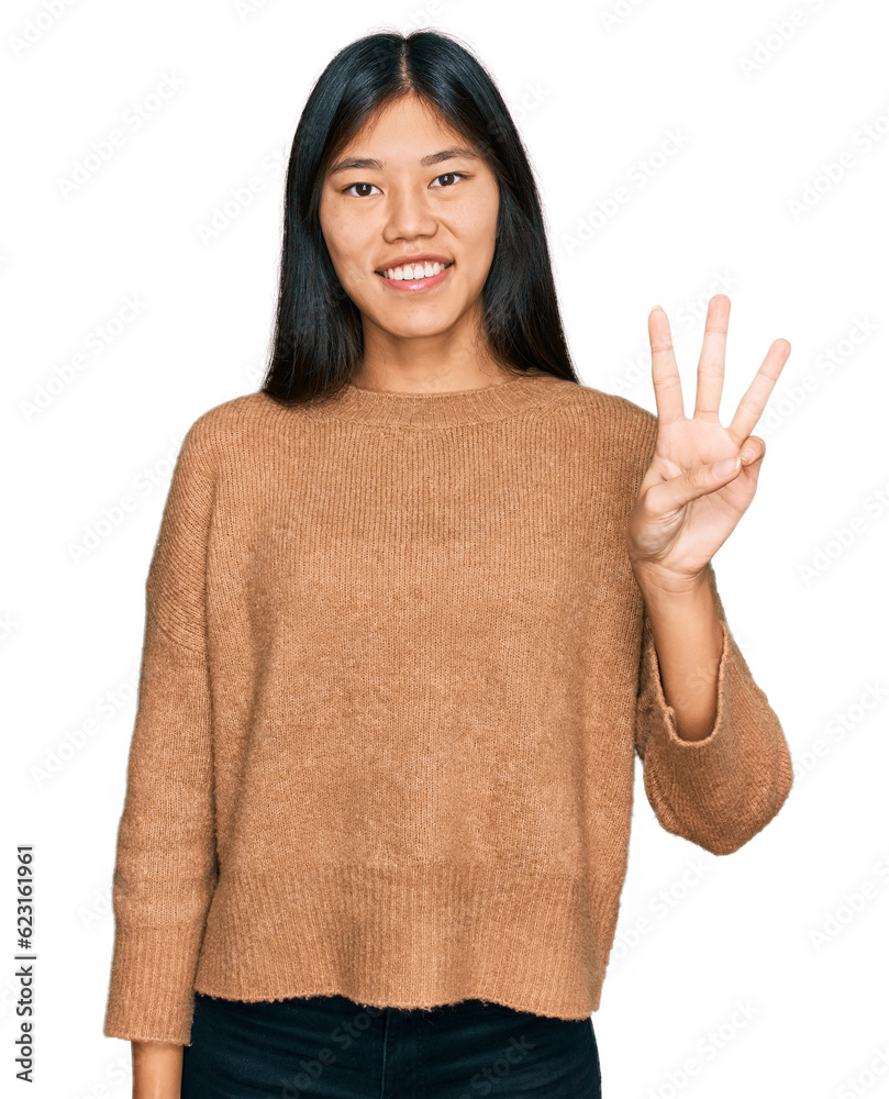 Beautiful young asian woman wearing casual winter sweater showing and pointing up with fingers number three while smiling confident and happy. Beautiful young asian woman wearing casual winter sweater showing and pointing up with fingers number three while smiling confident and happy.