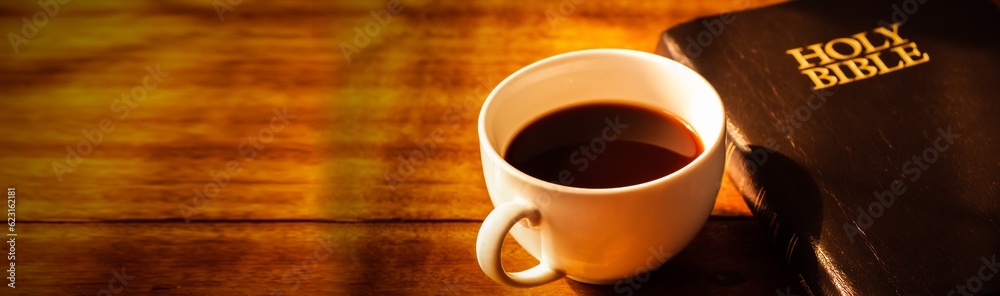 Close up of a cup of coffee and holy bible on wooden table, Bokeh light effected for web page cover Close up of a cup of coffee and holy bible on wooden table, Bokeh light effected for web page cover