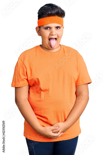 Little boy kid wearing sportswear sticking tongue out happy with funny expression. emotion concept.