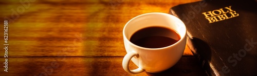 Close up of a cup of coffee and holy bible  on wooden table, Bokeh light effected for web page cover