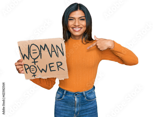 Young latin transsexual transgender woman holding woman power banner pointing finger to one self smiling happy and proud