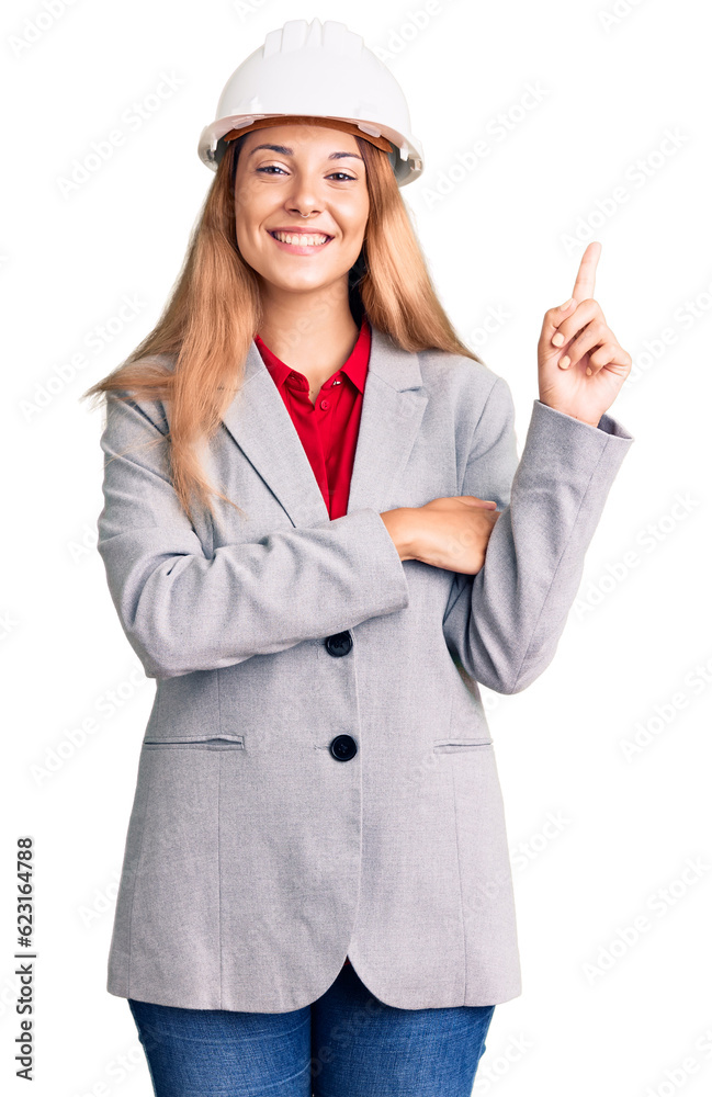 Beautiful young woman wearing architect hardhat with a big smile on face, pointing with hand and finger to the side looking at the camera. Beautiful young woman wearing architect hardhat with a big smile on face, pointing with hand and finger to the side looking at the camera.