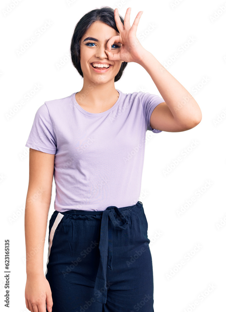 Brunette teenager girl wearing casual clothes doing ok gesture with hand smiling, eye looking through fingers with happy face. Brunette teenager girl wearing casual clothes doing ok gesture with hand smiling, eye looking through fingers with happy face.