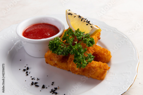 Fried cheese sticks in a bowl. On a light background.