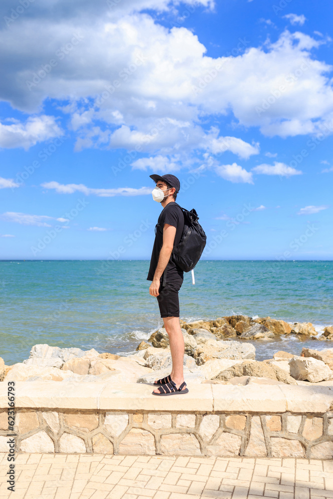 Male traveler enjoying seascape under sky during summer trip Male traveler enjoying seascape under sky during summer trip