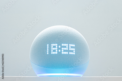 echo dot voice controlled speaker with blue neon activated voice recognition, on white background.