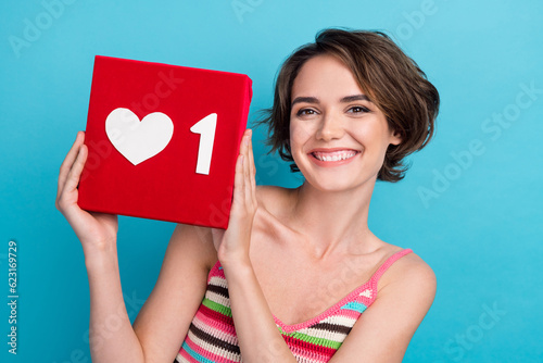 Portrait of cheerful lovely lady beaming smile good mood arms hold like notification isolated on blue color background