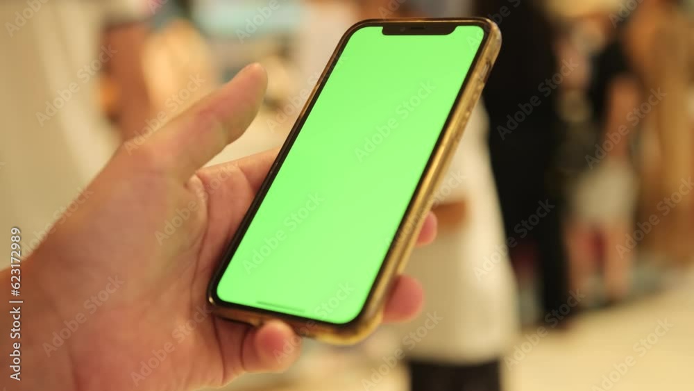View of woman at phone with green screen for chromakey, looking at mobile screen close-up. Modern wireless tech user concept