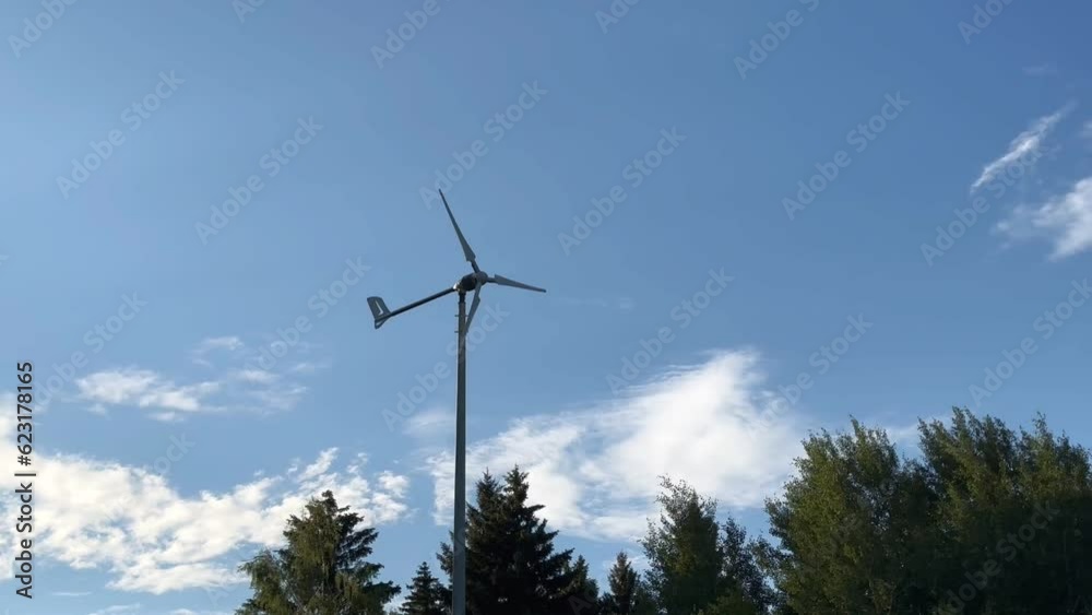 Small windmill with blades rotating at light windy weather, eco-friendly sustainable green renewable electric energy Small windmill with blades rotating at light windy weather, eco-friendly sustainable green renewable electric energy