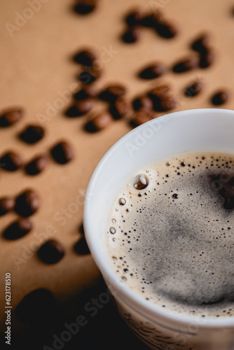 Close up of coffee foam and scattered beans on the background