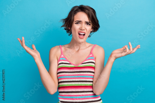 Photo of shocked impressed woman dressed striped tank top rising arms isolated blue color background