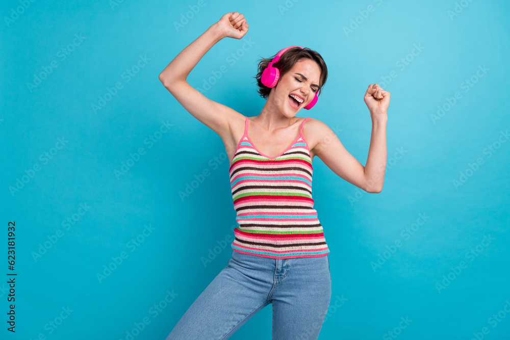 Portrait of nice overjoyed excited lady closed eyes enjoy sound headphones dancing isolated on blue color background Portrait of nice overjoyed excited lady closed eyes enjoy sound headphones dancing isolated on blue color background