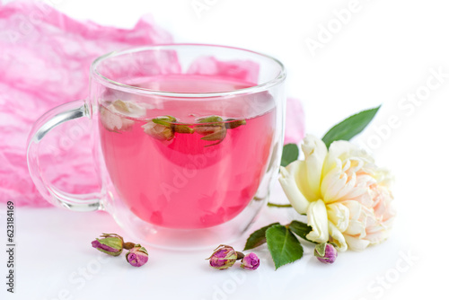 Cup of roses tea with rose buds on white background