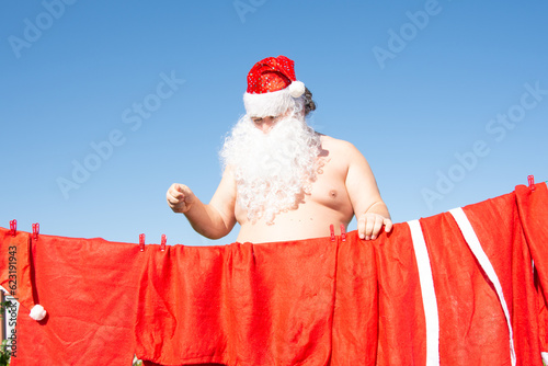 Funny Santa Claus is washing his costume.