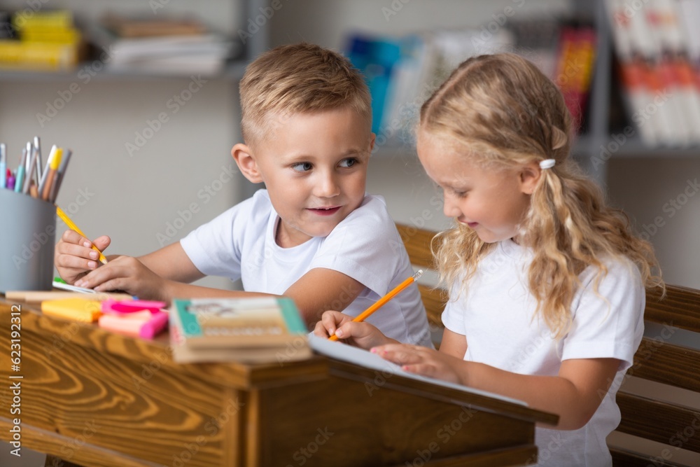 Children reading books sitting for table Children reading books sitting for table