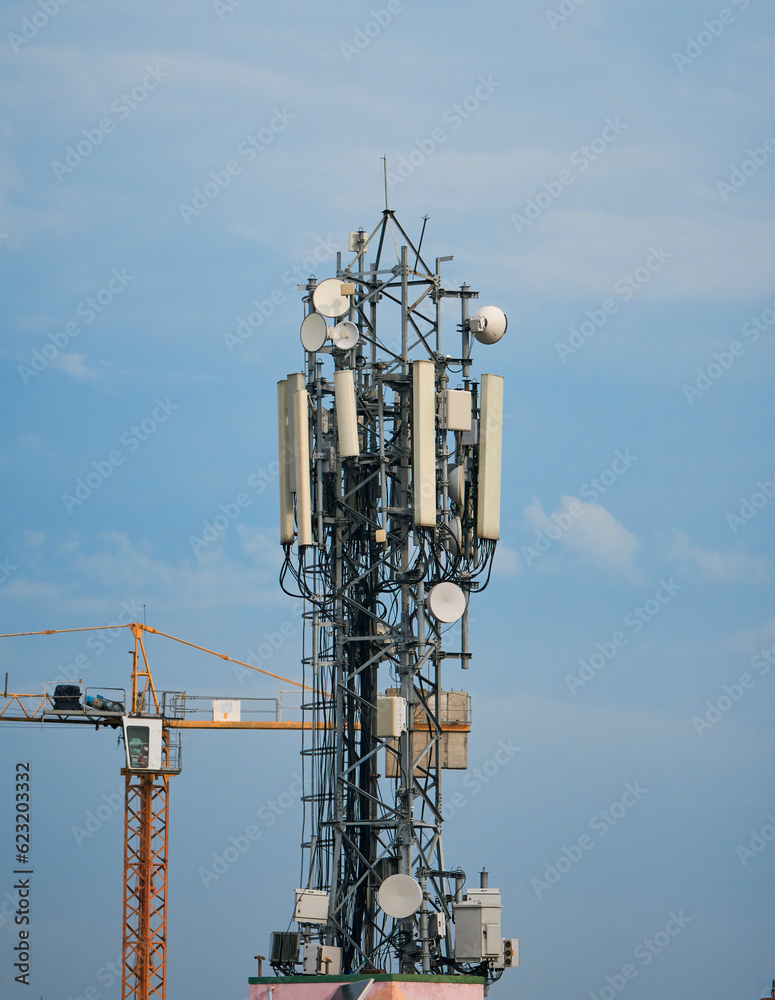 communication (cellular phone network) tower with antenna on rooftop of high rise building in suburban West Bengal. communication (cellular phone network) tower with antenna on rooftop of high rise building in suburban West Bengal.