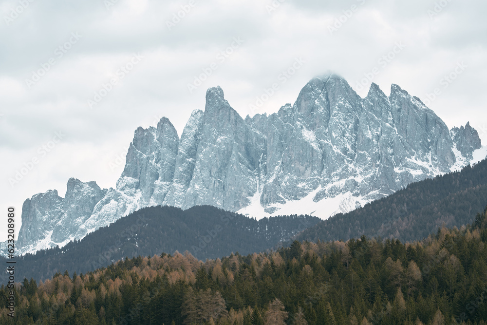 The mysterious beauty of the alpine landscape. The moody tones of the rugged peaks contrast against the greenery of the valley. The Dolomites, Italian Alps.