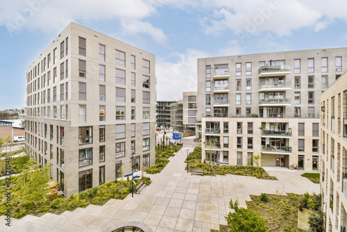 an urban area with buildings and trees in the middle part of the photo is taken from the top floor to the ground