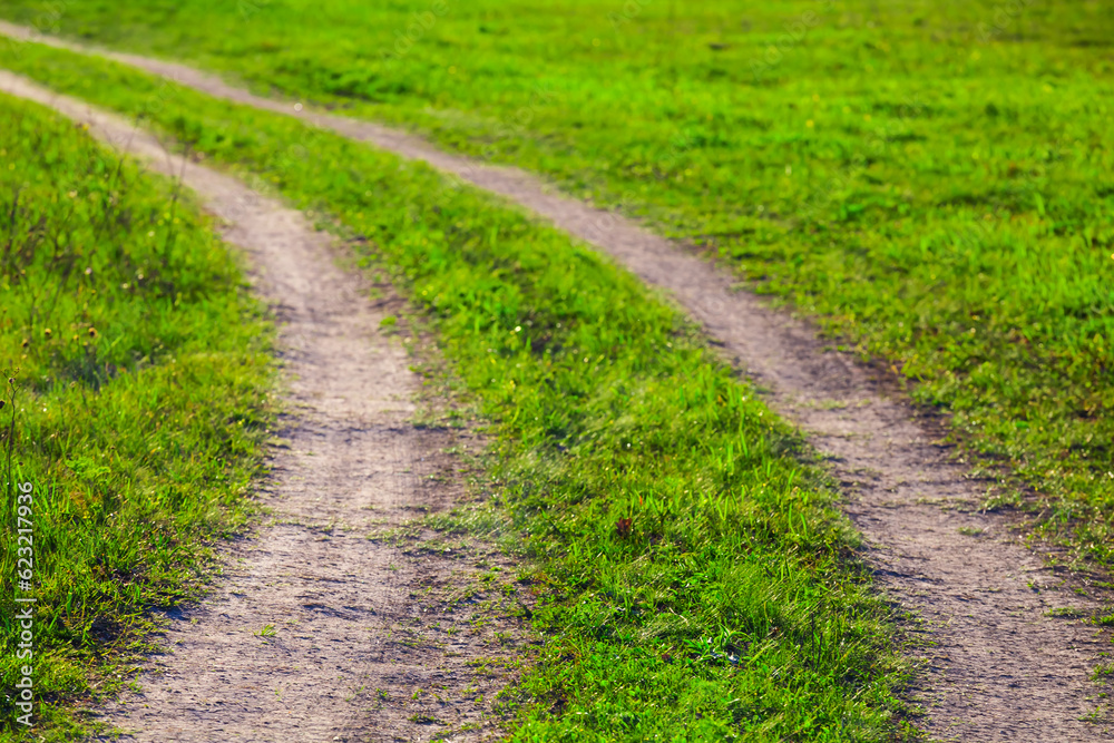 closeup ground road turn among green fields closeup ground road turn among green fields