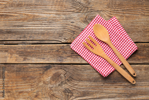 Folded napkin with cutlery on wooden background