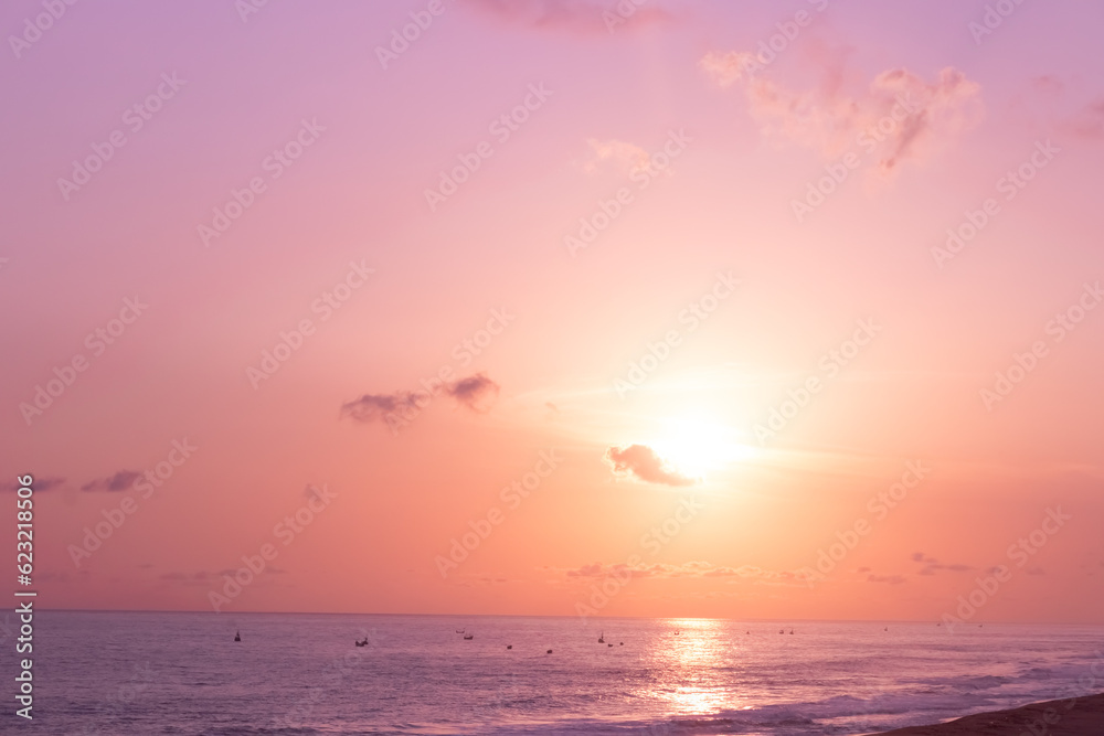 An enchanting image of a golden sunset, with clouds delicately painted in shades of purple and pink.