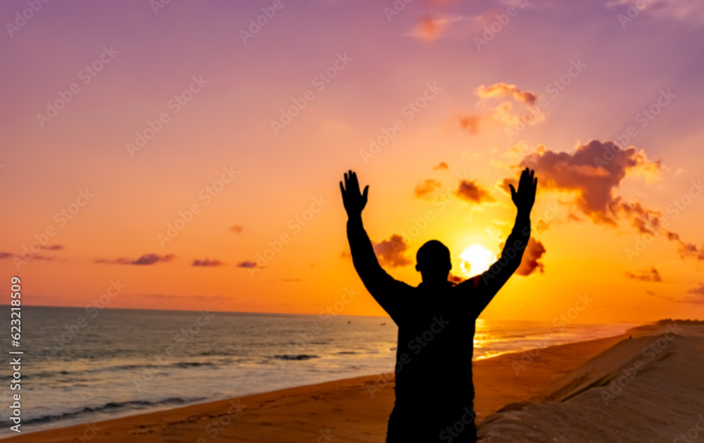 A captivating image of a man's silhouette, bathed in the golden hues of the solstice sunset, his hands clasped in prayer, reflecting his deep devotion to Jesus.