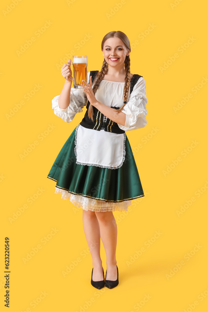 Beautiful Octoberfest waitress with beer on yellow background Beautiful Octoberfest waitress with beer on yellow background