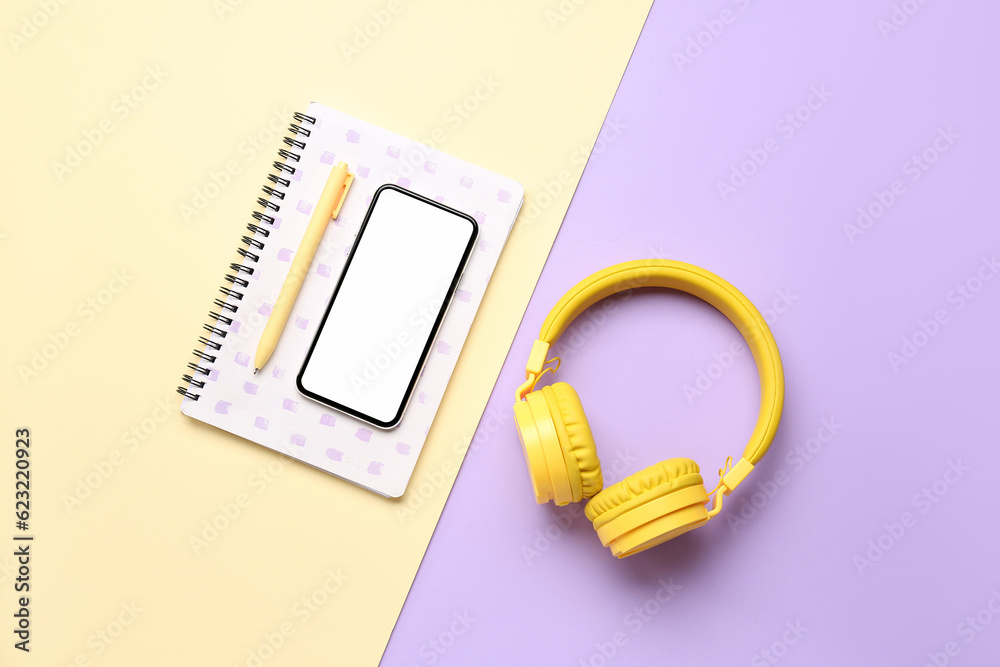 Stationery with headphones and mobile phone on color background Stationery with headphones and mobile phone on color background