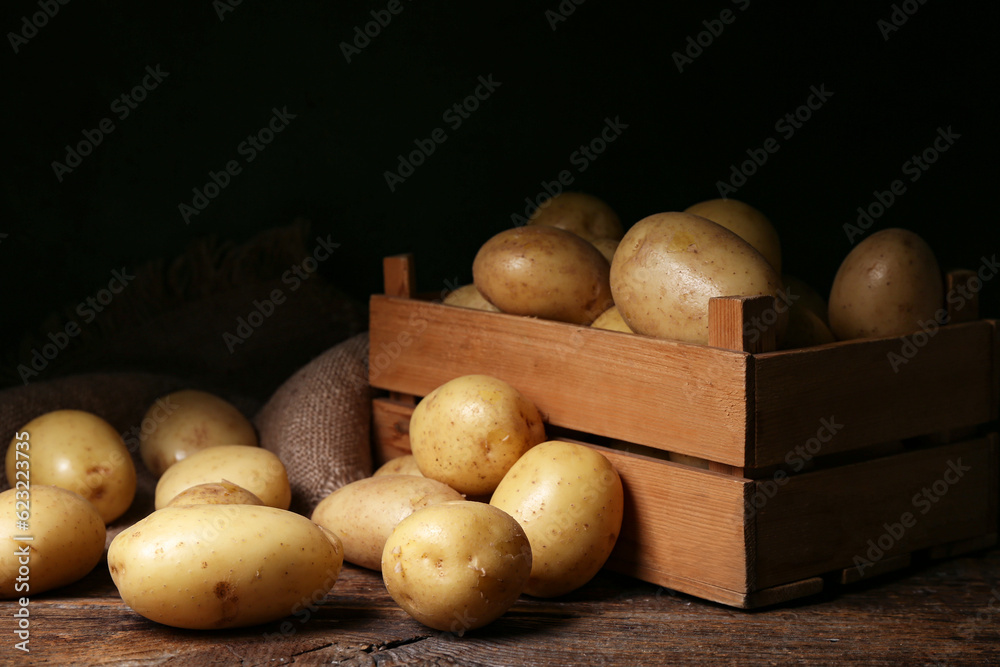 Box with raw potatoes on wooden table Box with raw potatoes on wooden table