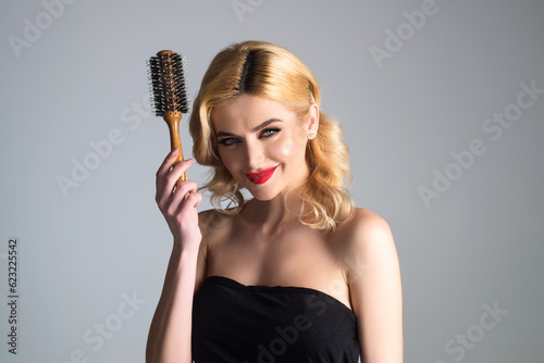 Beautiful woman combing her hair in studio.
