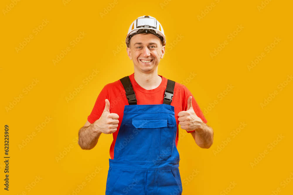 Young architect man or engineer or worker over isolated yellow background shows thumbs up and smile. Copy space. Young architect man or engineer or worker over isolated yellow background shows thumbs up and smile. Copy space.