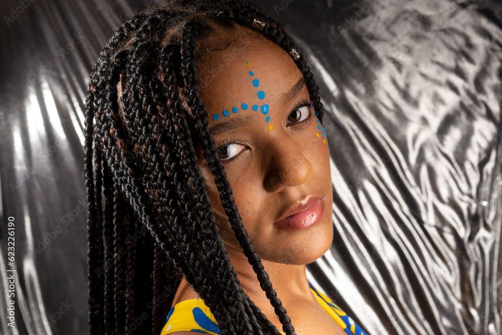 Close-up portrait of a beautiful black woman with colorful paint on her face.