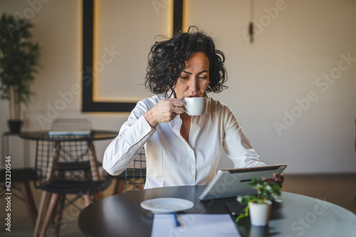 One woman mature female entrepreneur use digital tablet for work