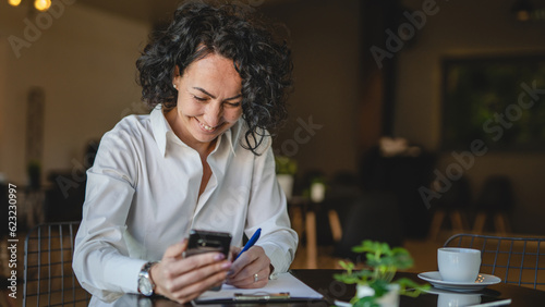 One woman mature female entrepreneur use smartphone phone at work