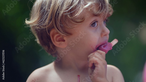 Child eating ice cream outside during summer day one messy little boy eats sweet dessert