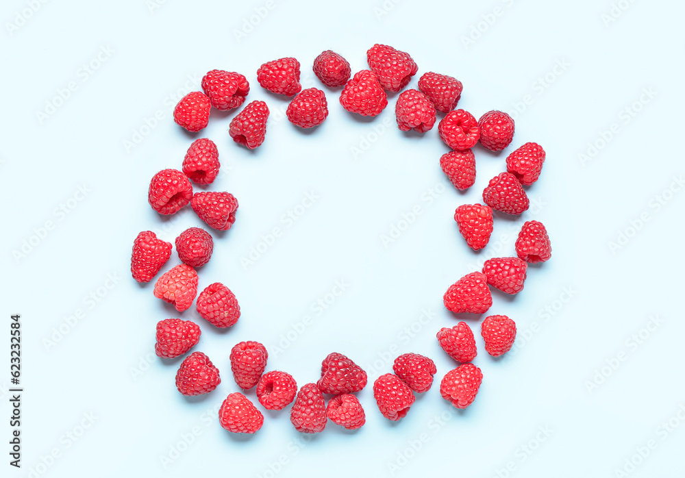 Frame made of fresh raspberries on blue background Frame made of fresh raspberries on blue background