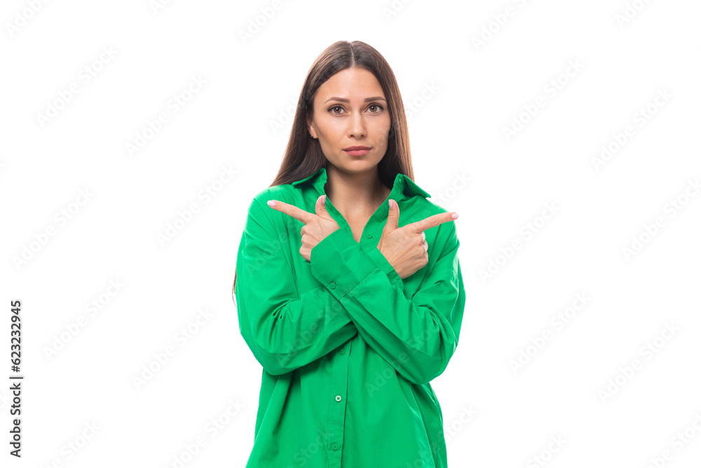 young european female model with well-groomed black hair and make-up dressed in a green shirt crossed her arms in front of her on a white background with copy space young european female model with well-groomed black hair and make-up dressed in a green shirt crossed her arms in front of her on a white background with copy space