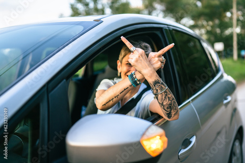 woman senior mature driver show middle finger trough the window of car