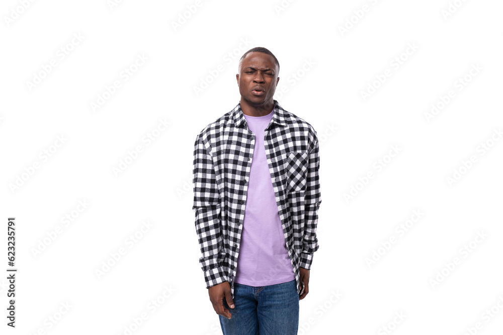 young handsome dark skinned man in a plaid shirt and jeans looking smiling at the camera on an isolated white background with copy space young handsome dark skinned man in a plaid shirt and jeans looking smiling at the camera on an isolated white background with copy space